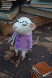 Mouse in woolly jumper with glasses and a book